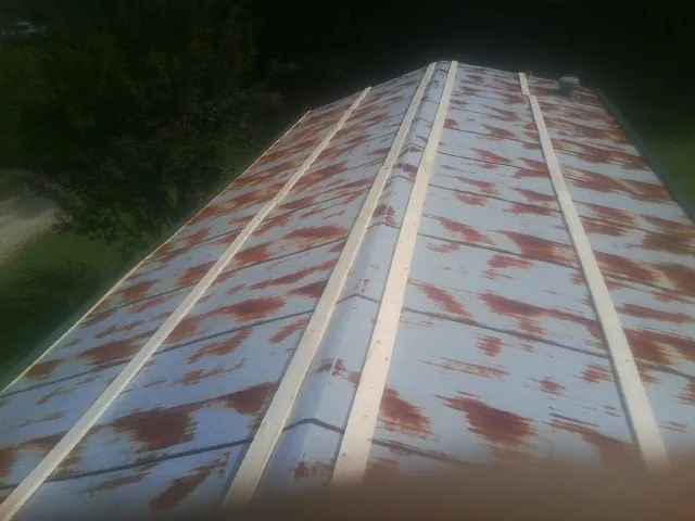 Rusted metal roof panels with new wood purlins before replacement — Storm Damage Roof Repair in South Gardiner by Roofing Brothers
