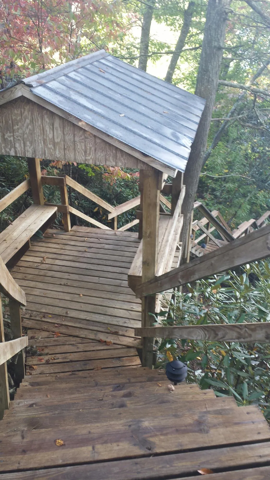 Metal roofed shelter over wooden steps on a wooded walkway — Skylight Repair & Installation work by our crew in South Gardiner
