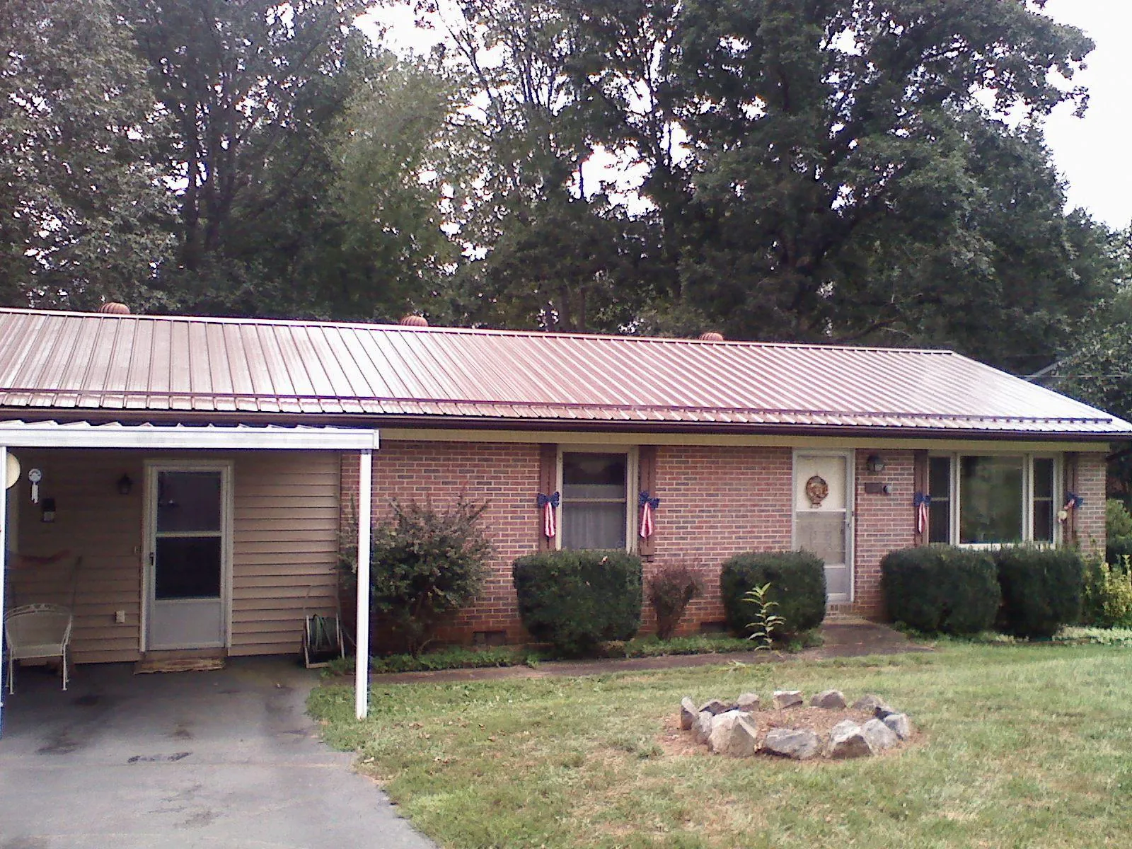 Bronze metal roof and carport on a brick ranch home — Roof Repair work by our crew in South Gardiner